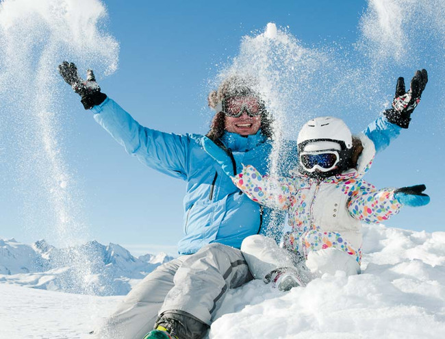 Familie hat Spaß im Skiurlaub und spielt im Schnee