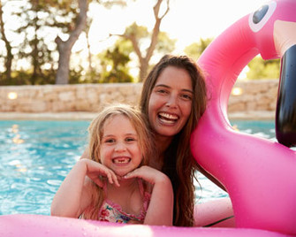 Mutter und Tochter im Pool vom Ferienhaus im Familienurlaub